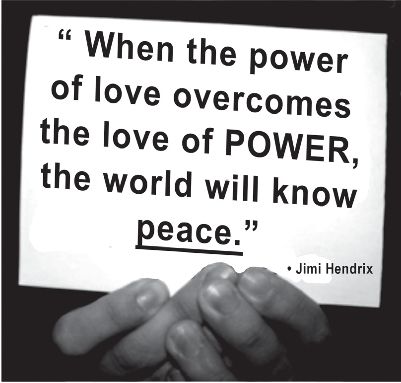Fotografia de mãos segurando um cartaz branco com a frase em letras pretas: “When the power of love overcomes the love of POWER, the world will know peace.”, com “peace” sublinhado, e a atribuição “• Jimi Hendrix”.