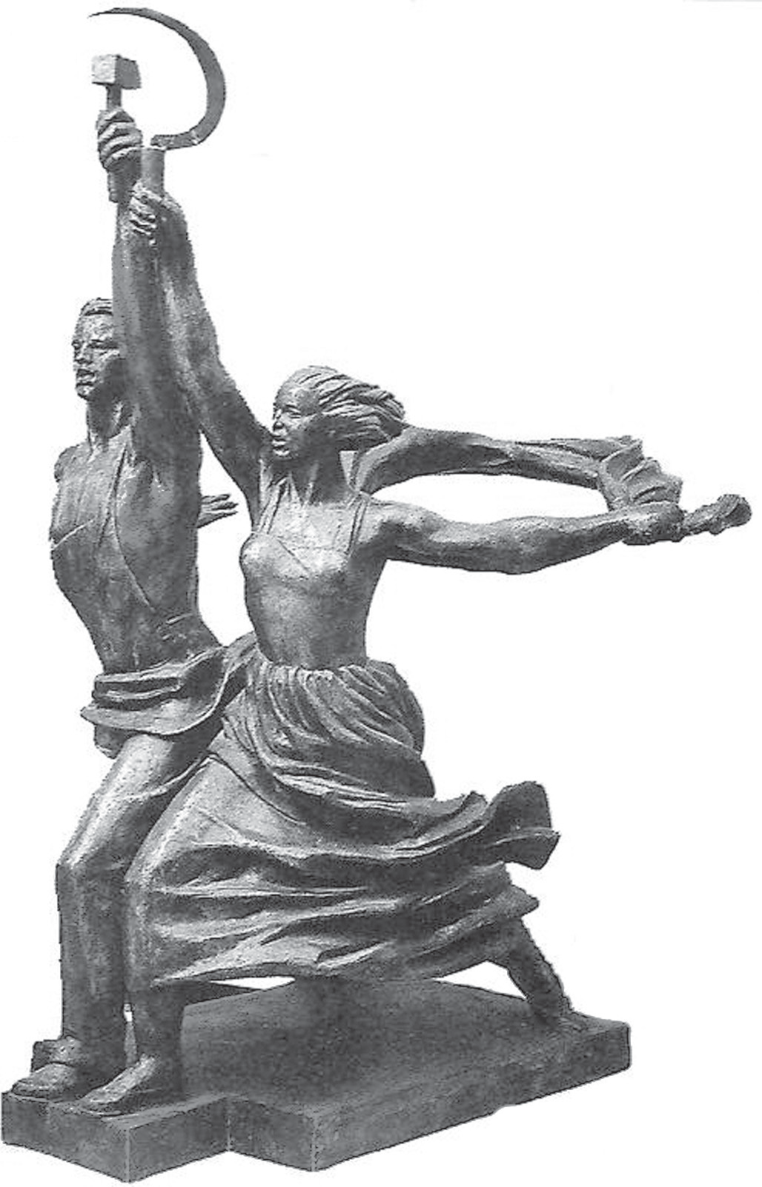 Fotografia em preto e branco de uma escultura monumental de aço: um homem e uma mulher lado a lado, em passo largo para a frente, erguendo juntos os braços; ele segura um martelo e ela uma foice, unidos no alto. As roupas e o cabelo da mulher parecem agitados pelo vento; a base é um pedestal escalonado.