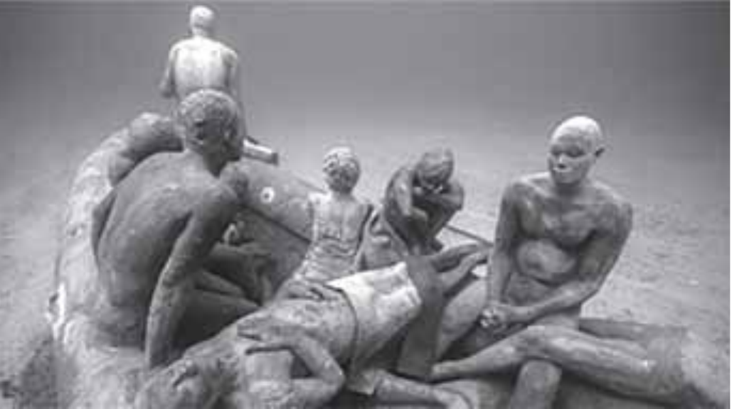 Fotografia de esculturas de pessoas em uma embarcação submersa.
