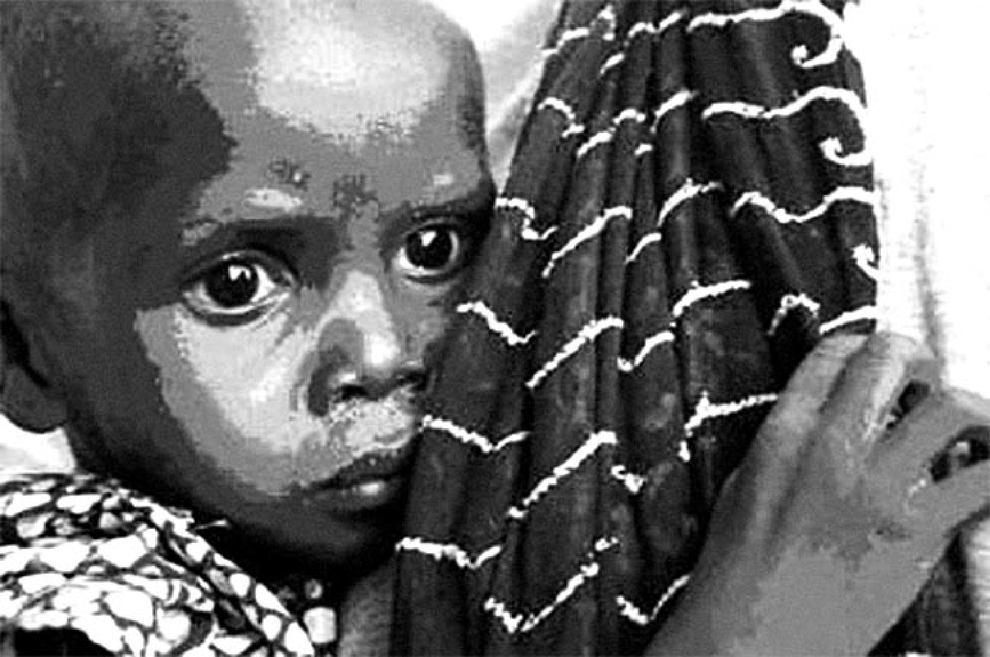 Fotografia em preto e branco de uma criança africana, com o rosto próximo da câmera e olhar sério, envolta por tecidos estampados; uma mão adulta segura a criança.