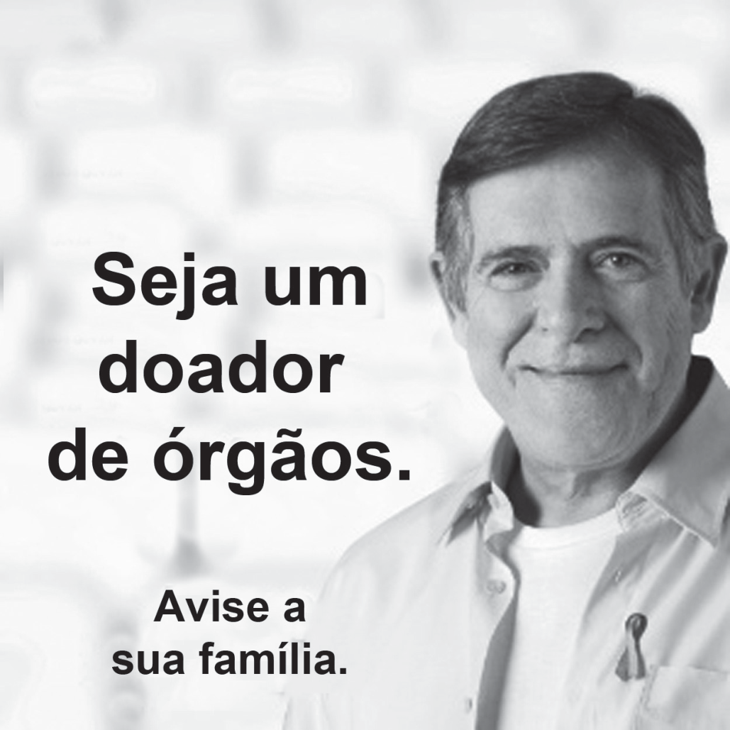 Cartaz de campanha com a foto de um homem sorridente, de camisa clara, usando um laço no peito. À esquerda, em letras grandes: Seja um doador de órgãos. Abaixo, em letras menores: Avise a sua família.