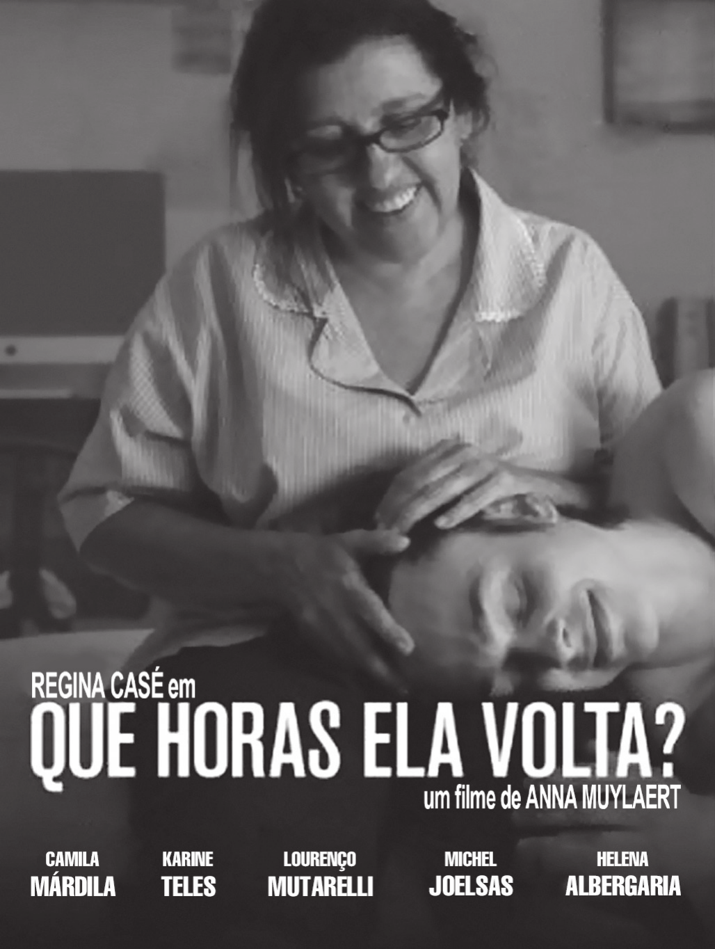 Cartaz de filme: uma mulher de óculos, sentada, sorri enquanto acaricia a cabeça de um rapaz deitado em seu colo, num quarto simples. Na parte de baixo, sobre a fotografia, o crédito da atriz, o título em letras grandes, o crédito de direção e os nomes do elenco.

REGINA CASÉ em QUE HORAS ELA VOLTA? um filme de ANNA MUYLAERT
CAMILA MÁRDILA · KARINE TELES · LOURENÇO MUTARELLI · MICHEL JOELSAS · HELENA ALBERGARIA